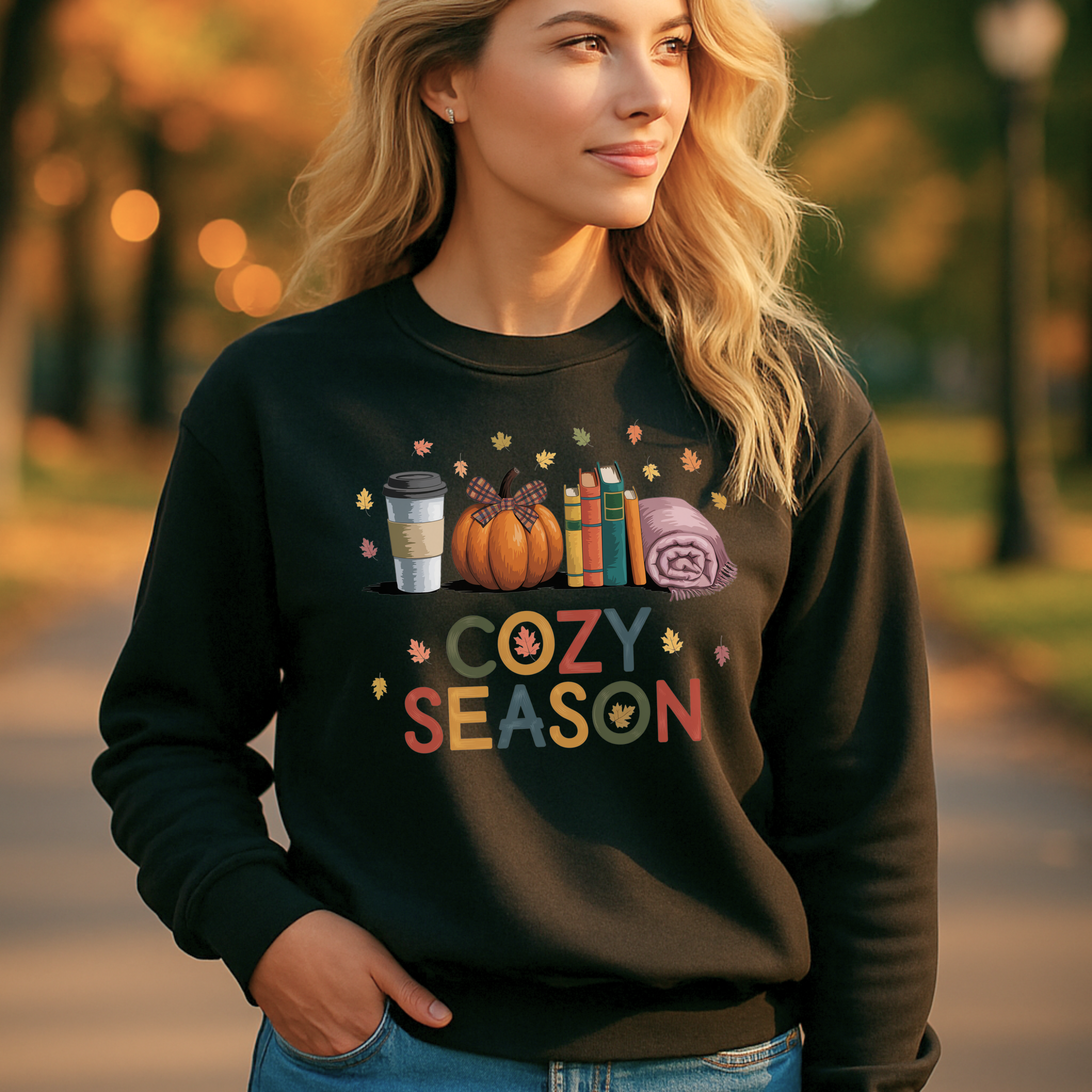 A woman wearing a sweatshirt from the PinkWolf & Co. shop on Etsy that has a Cozy season design.